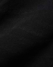 Kids Emerson Denim Pant, showcasing the rich, deep black denim fabric with a distinct diagonal twill weave texture. The premium quality material is subtly creased, highlighting its refined finish.