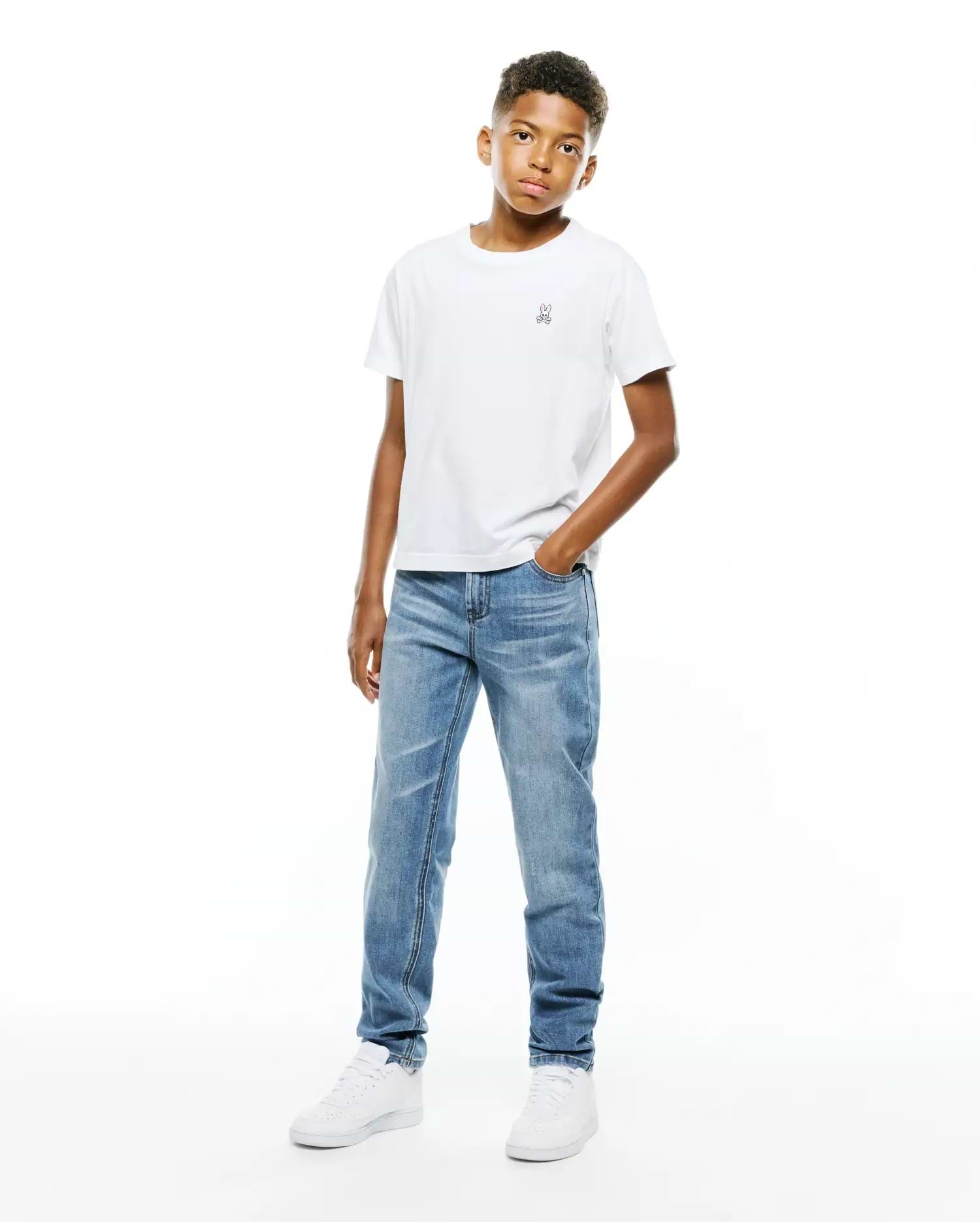 White classic fit jersey t-shirt featuring a small embroidered Psycho Bunny skull logo on the left chest, paired with light blue washed Kids Emerson Denim Pant.
