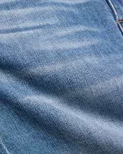 Kids Emerson Denim Pant featuring a classic medium blue washed denim with a prominent twill weave texture, natural fading, and subtle creasing, accented by visible warm brown stitching.