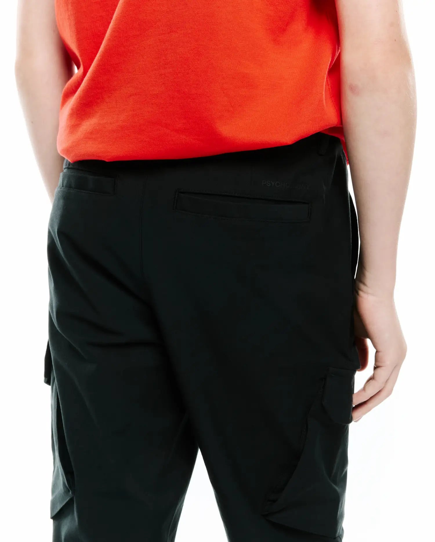 Black Kids Luka Cargo Pant, relaxed fit, smooth fabric, with side cargo pockets, flap back pockets, and a subtle tonal Psycho Bunny text logo on the back waistband.