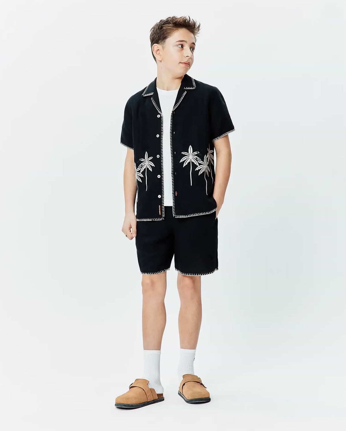 Black short-sleeve button-up shirt with white contrast stitching and palm tree embroidery, paired with matching Black Kids Brad Linen Short featuring white contrast stitching, both in a relaxed fit.