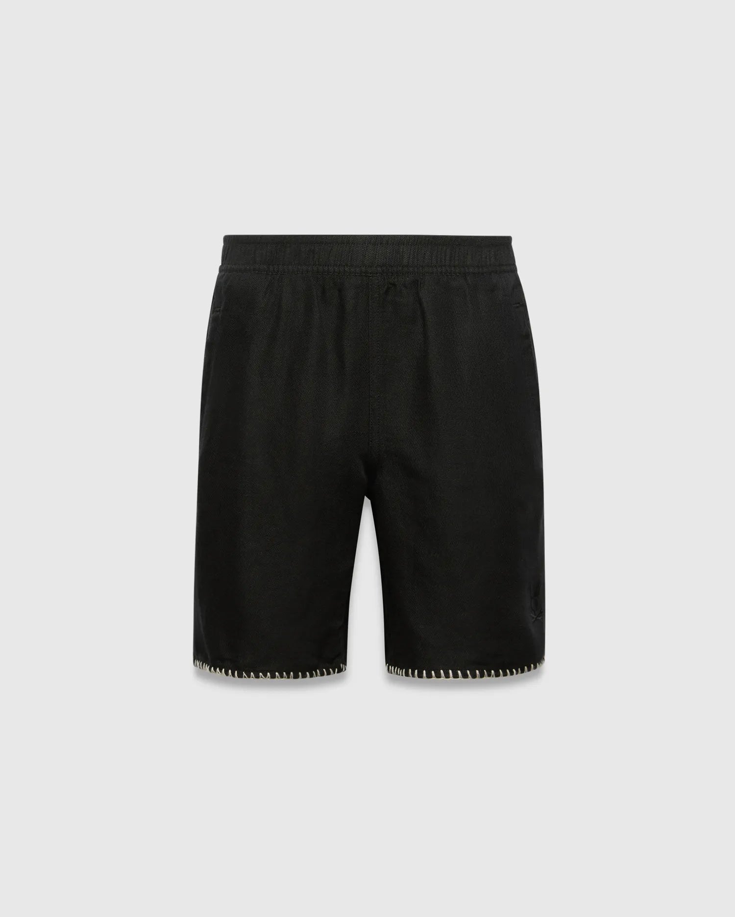 Kids Brad Linen Short, black relaxed fit with linen texture, featuring a subtle tonal embroidered Psycho Bunny skull logo on the lower right leg and white contrast blanket stitching on the hem.
