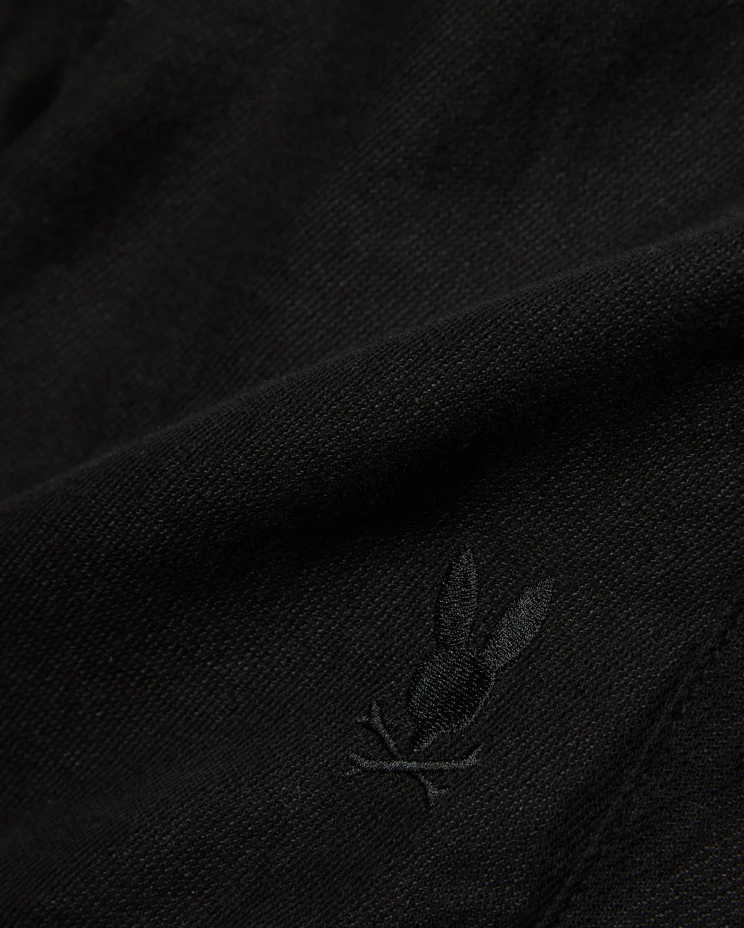 Kids Brad Linen Short in classic black, crafted from a breathable linen blend with a subtle woven texture, featuring a small, tonal embroidered Psycho Bunny skull logo.