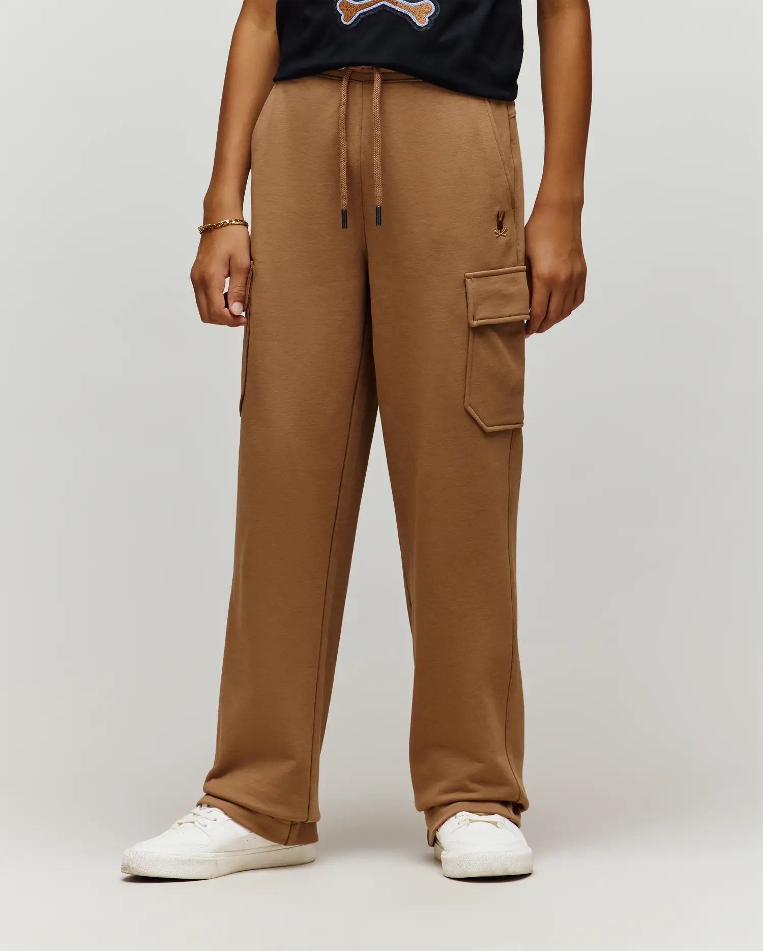 Camel brown French terry Kids Nash Cargo Sweatpant with a relaxed wide-leg fit, drawstring waist with black tips, a cargo pocket, and a small embroidered Psycho Bunny skull logo on the right thigh.