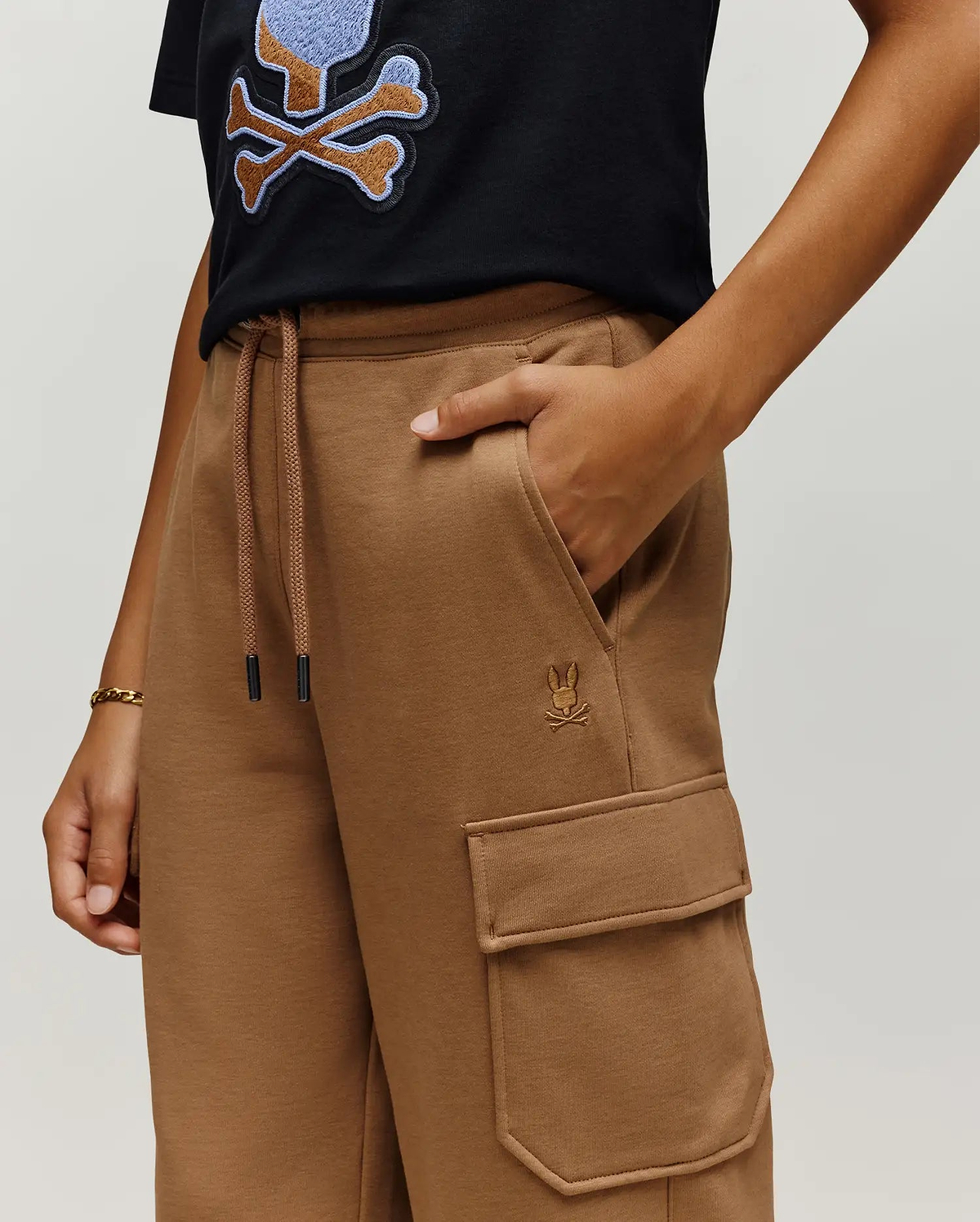 Camel brown Kids Nash Cargo Sweatpant, featuring a relaxed fit, soft French terry fabric, drawstring waist, a tonal embroidered Psycho Bunny skull logo on the left thigh, and a cargo pocket.