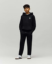 Black Kids Timothy 4k Bunny Jogger and matching hoodie, both featuring a small white embroidered Psycho Bunny skull logo on the left chest and left thigh, in a relaxed fit soft French terry fabric.