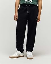 Kids Tate Chenille Sweatpant in black french terry, featuring a relaxed fit, drawstring waist, and a white chenille Psycho Bunny skull logo on the right thigh.