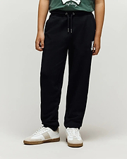 Kids Tate Chenille Sweatpant in black french terry, featuring a relaxed fit, drawstring waist, and a white chenille Psycho Bunny skull logo on the right thigh.