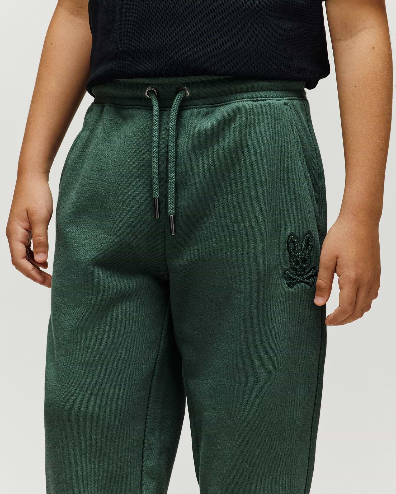 Kids Tate Chenille Sweatpant, forest green, relaxed fit, featuring a soft chenille knit, drawstring waist, side pockets, and a small tonal embroidered Psycho Bunny skull logo on the right thigh.