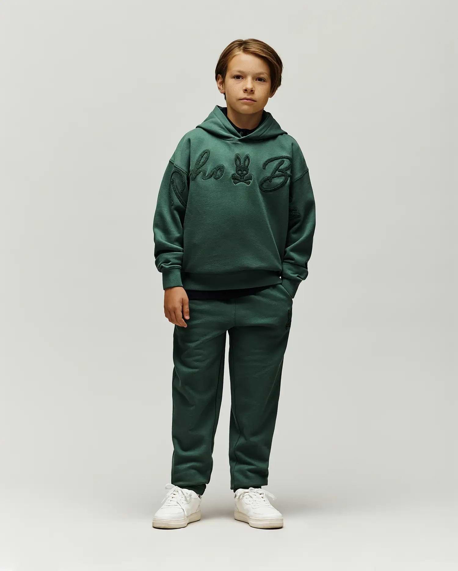 Forest green relaxed fit french terry hoodie with large tonal chenille Psycho Bunny script and skull logo on chest, paired with Kids Tate Chenille Sweatpant featuring a small tonal bunny skull logo.