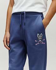 Kids Indigo Ski Bunny Sweatpant, relaxed fit, made from soft french terry, features a medium-sized embroidered Psycho Bunny skull with ski goggles and crossed pink skis on the left thigh.