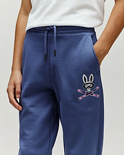 Kids Indigo Ski Bunny Sweatpant, relaxed fit, made from soft french terry, features a medium-sized embroidered Psycho Bunny skull with ski goggles and crossed pink skis on the left thigh.