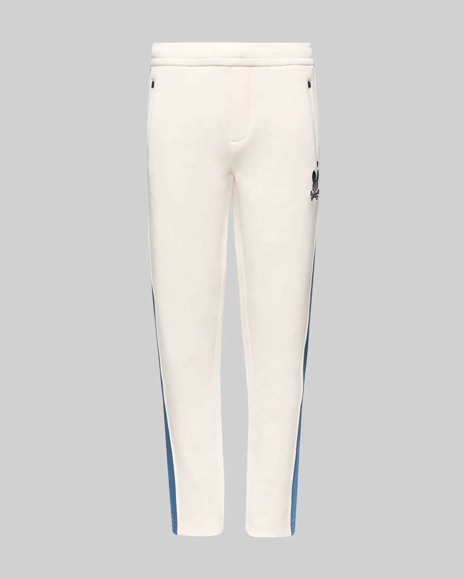 Kids Caspian Contrast Stripe Track Pant in cream, featuring a blue side stripe, relaxed fit, smooth fabric, and a small black embroidered Psycho Bunny skull logo on the upper right thigh.