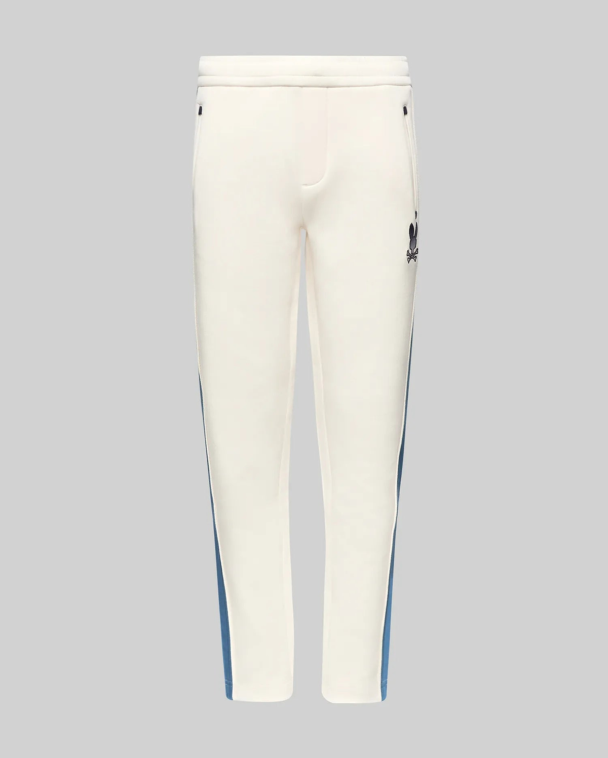 Kids Caspian Contrast Stripe Track Pant in cream, featuring a blue side stripe, relaxed fit, smooth fabric, and a small black embroidered Psycho Bunny skull logo on the upper right thigh.