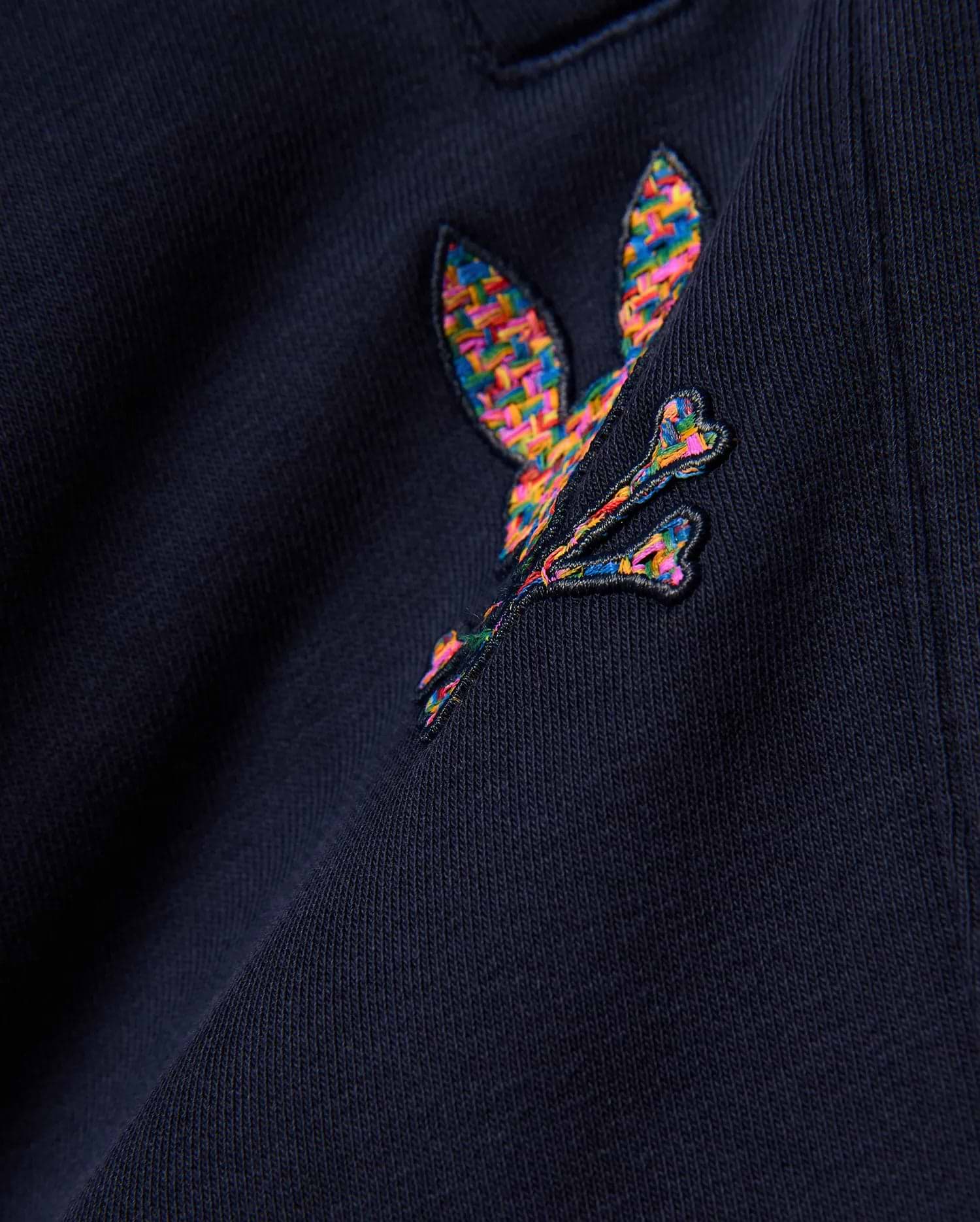 Kids Darcy Sweatpant in deep navy, crafted from soft jersey knit fabric, prominently featuring a medium-sized, intricately embroidered multicolor Psycho Bunny skull logo with a vibrant, woven texture.