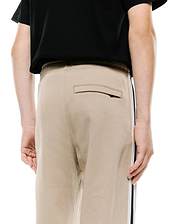 Kids Ty French Terry Sweatpant in beige, featuring a relaxed fit, soft french terry fabric, a back welt pocket, and a distinctive navy and white side stripe.