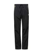 Kids Alder Nylon Colorblock Pant in black crinkled nylon with olive green side panels, featuring a relaxed fit and a small white Psycho Bunny skull logo on the right hip.