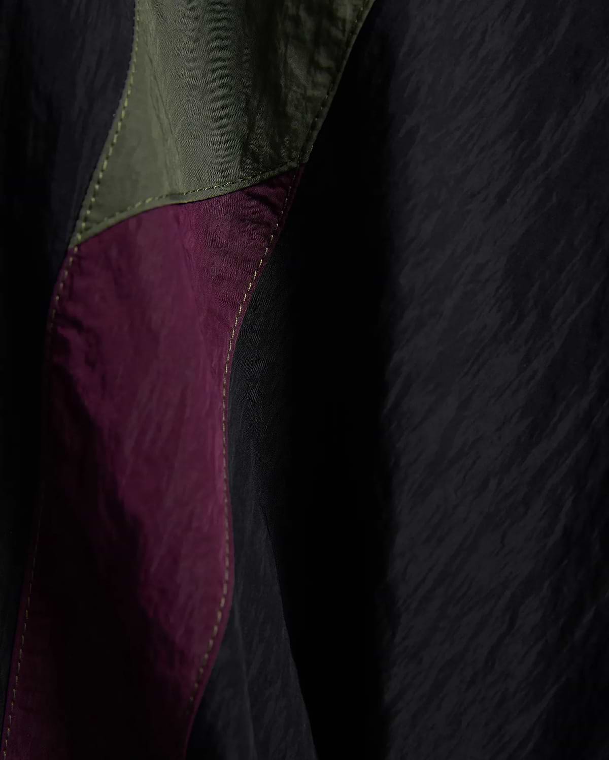 Kids Alder Nylon Colorblock Pant featuring crinkled black nylon with bold olive green and deep magenta colorblock panels, accented by prominent light yellow stitching.