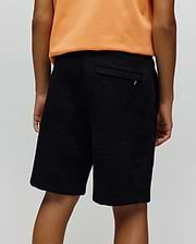 Kids Dustin Sweatshort, black relaxed fit with a subtle geometric textured jacquard knit pattern and a small silver Psycho Bunny logo tag on the back pocket.
