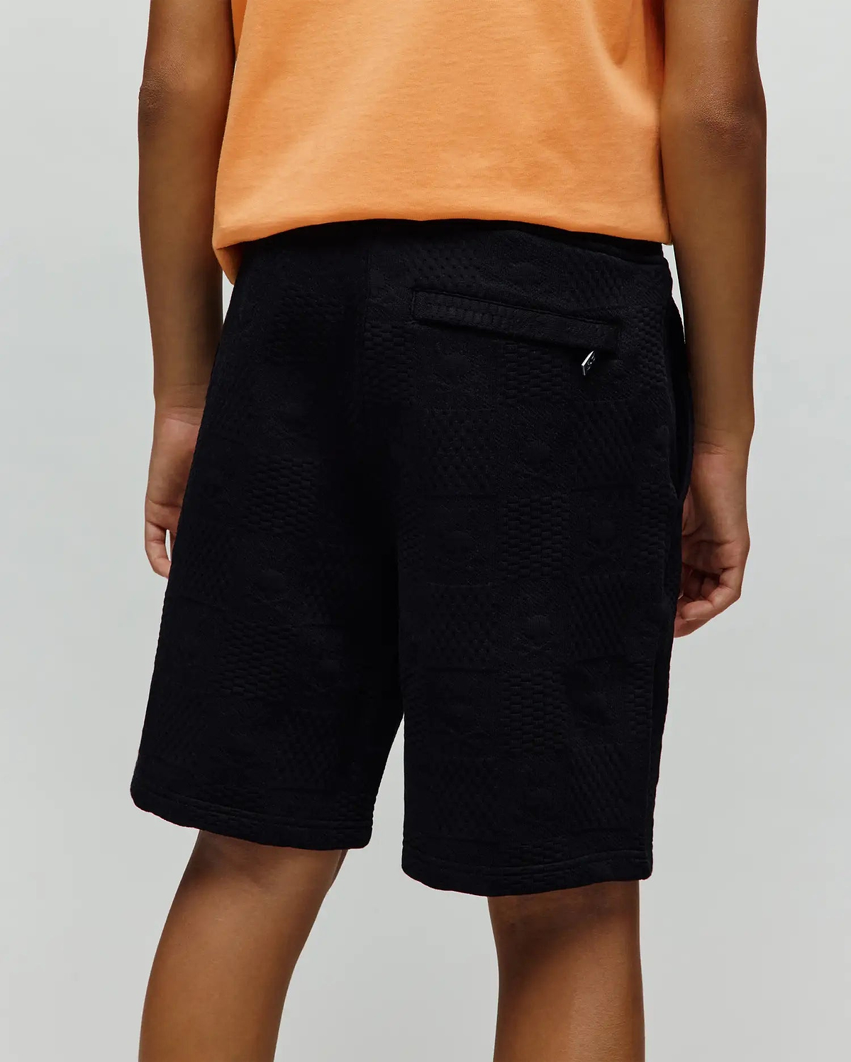 Kids Dustin Sweatshort, black relaxed fit with a subtle geometric textured jacquard knit pattern and a small silver Psycho Bunny logo tag on the back pocket.