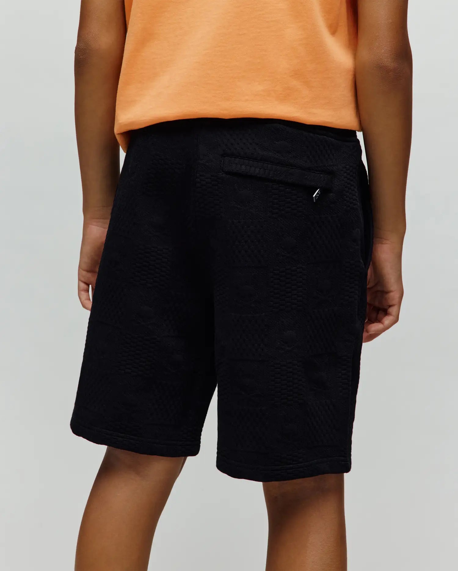 Kids Dustin Sweatshort, black relaxed fit with a subtle geometric textured jacquard knit pattern and a small silver Psycho Bunny logo tag on the back pocket.