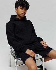 Black relaxed fit hoodie and Kids Dustin Sweatshort set, featuring an all-over subtle embossed Psycho Bunny skull logo pattern on textured knit fabric.