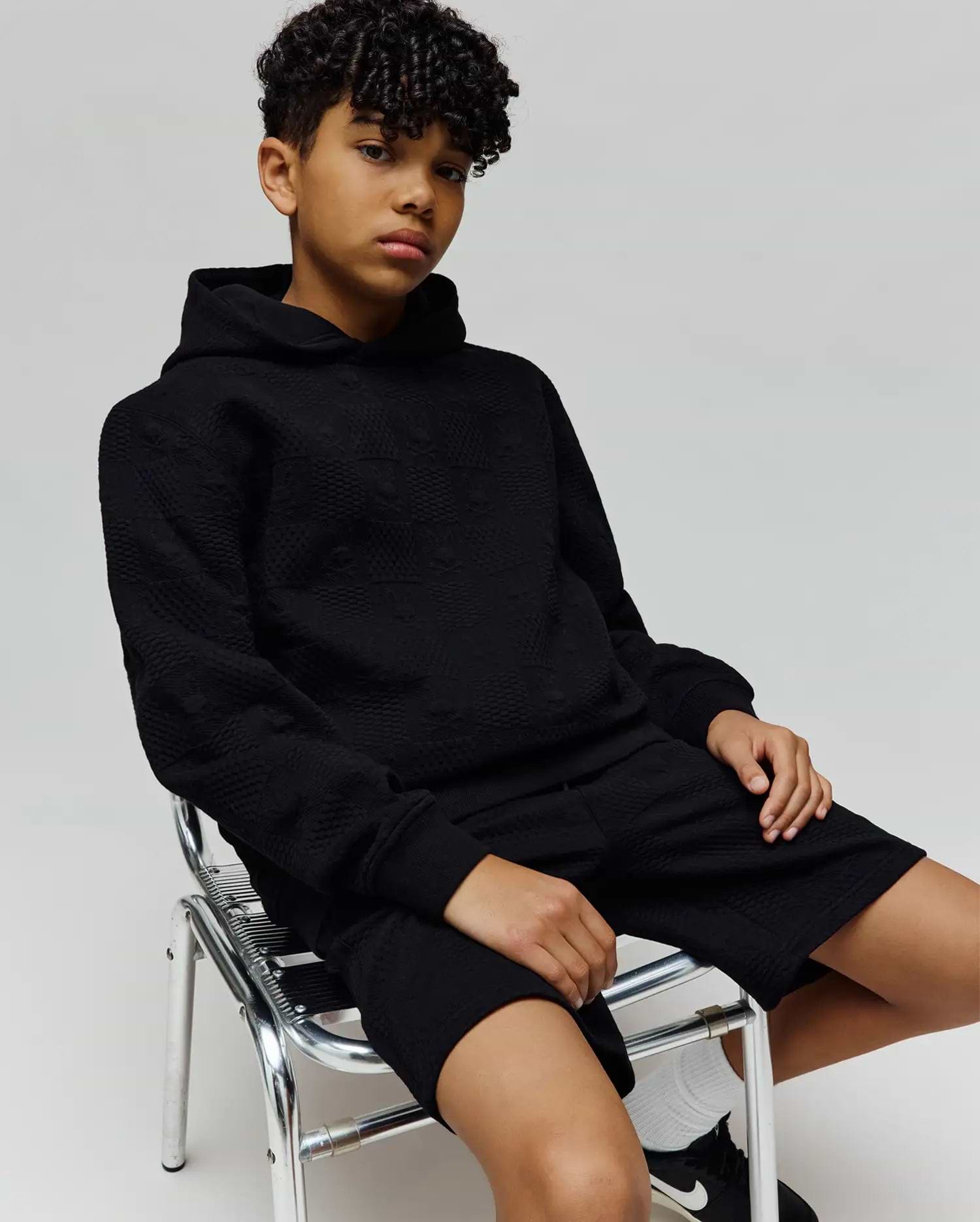 Black relaxed fit hoodie and Kids Dustin Sweatshort set, featuring an all-over subtle embossed Psycho Bunny skull logo pattern on textured knit fabric.