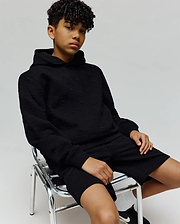Black relaxed fit hoodie and Kids Dustin Sweatshort set, featuring an all-over subtle embossed Psycho Bunny skull logo pattern on textured knit fabric.