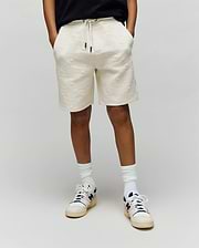 Kids Dustin Sweatshort in cream, featuring a relaxed fit and an allover embossed Psycho Bunny skull and crossbones pattern on textured knit fabric with a drawstring waist.