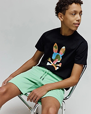 Black jersey t-shirt with a large multi-color camo Psycho Bunny skull graphic on the chest, paired with Kids Barry Modal Short in mint green featuring a drawstring waist and small tonal embroidered logo.