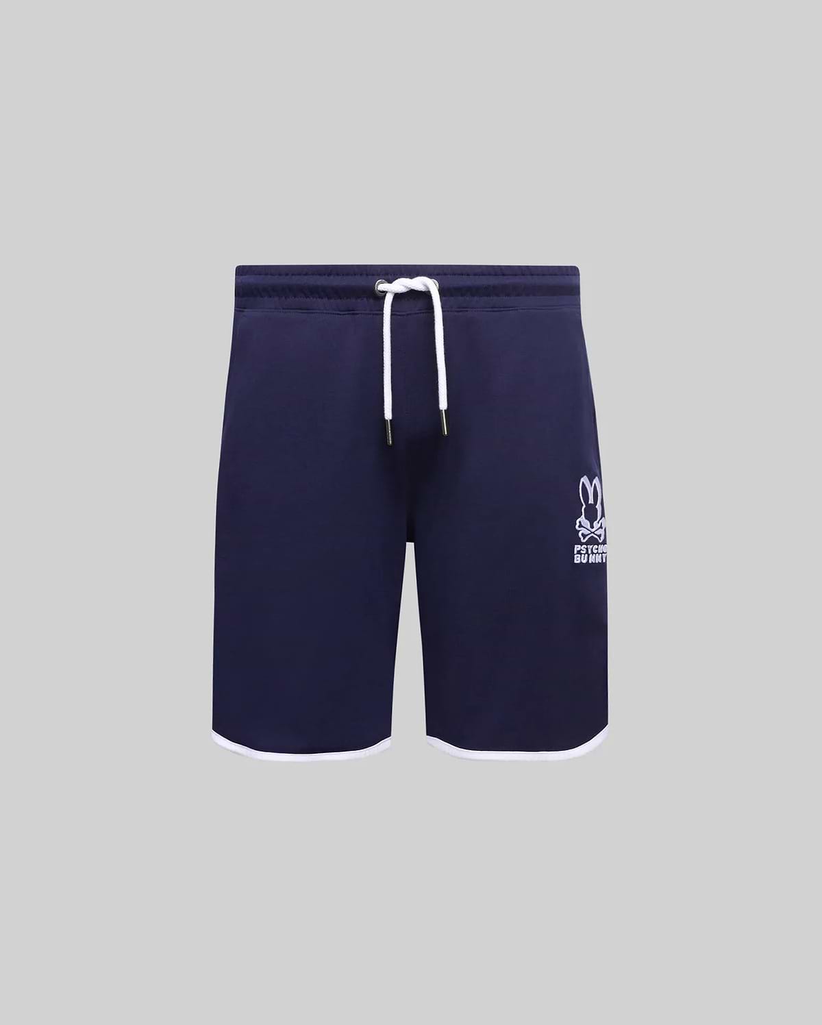 Kids Toby Short, navy French terry with white drawstring, gold tips, and white hem trim. Features an embroidered white Psycho Bunny skull logo on the right thigh.