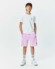 White jersey t-shirt with small embroidered Psycho Bunny logo on left chest, paired with Kids Keith Short 3 1/2 in light pink french terry, featuring a larger embroidered Psycho Bunny logo on the left leg and dark pink pocket trim.