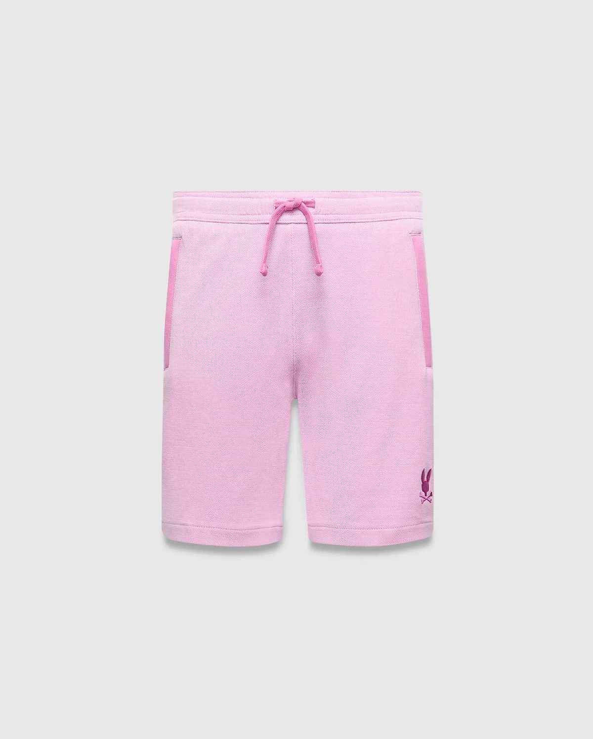 Kids Keith Short, a relaxed fit pink jersey short with magenta drawstring, side pocket trim, and a small embroidered Psycho Bunny skull logo on the lower left leg.