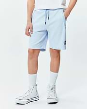 Kids Keith Short 3 1/2, light blue pique knit, relaxed fit with drawstring waist, side pockets, and a small embroidered navy Psycho Bunny skull logo on the left leg. (1)