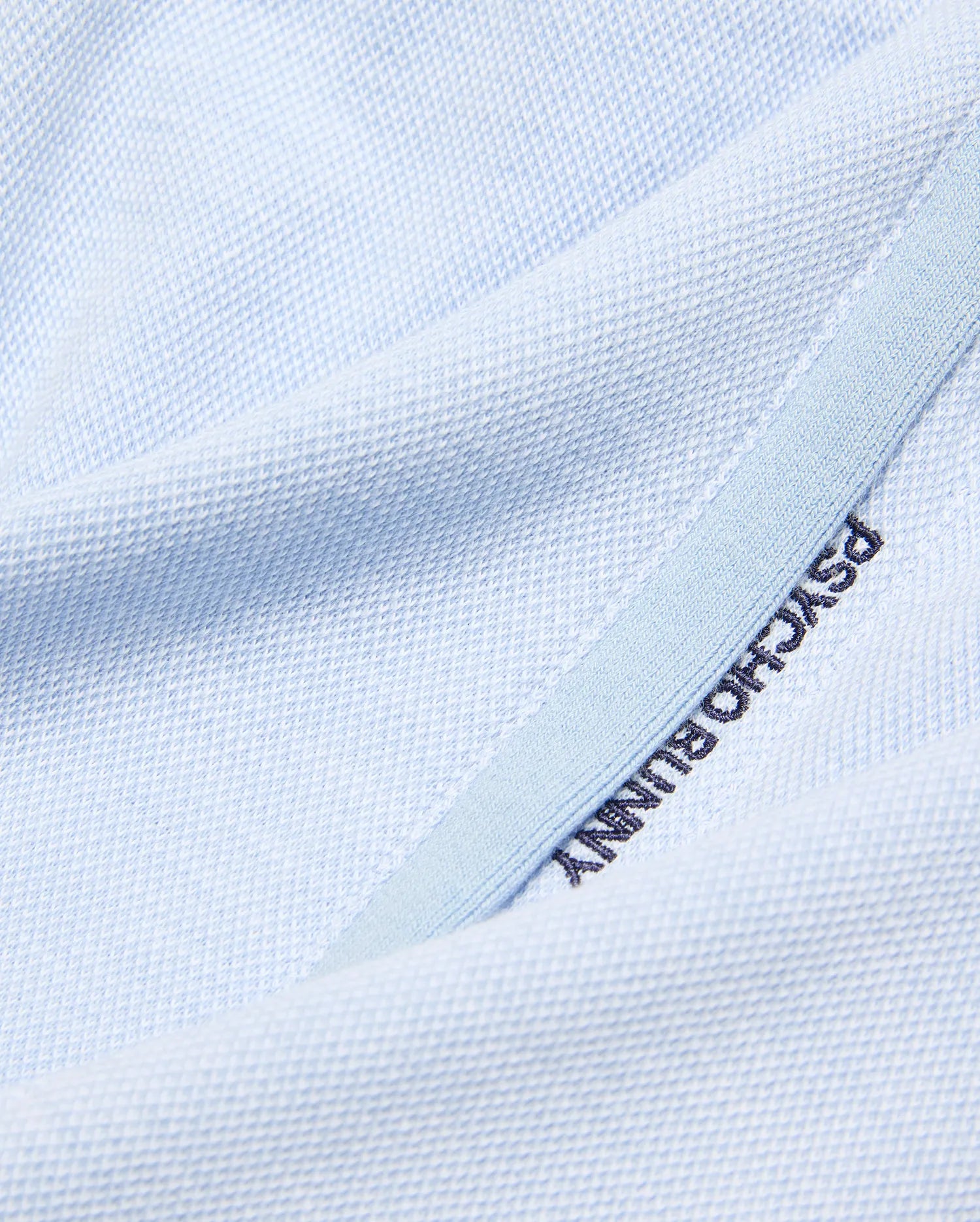 Light blue pique knit Kids Keith Short, showcasing premium streetwear with dark blue embroidered PSYCHO BUNNY text on a subtle lighter blue trim. (6)