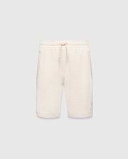 Kids Keith Short 3 1/2, a cream textured knit relaxed fit short with drawstring waist, light beige pocket trim, and a small embroidered light blue Psycho Bunny skull logo on the lower left leg.