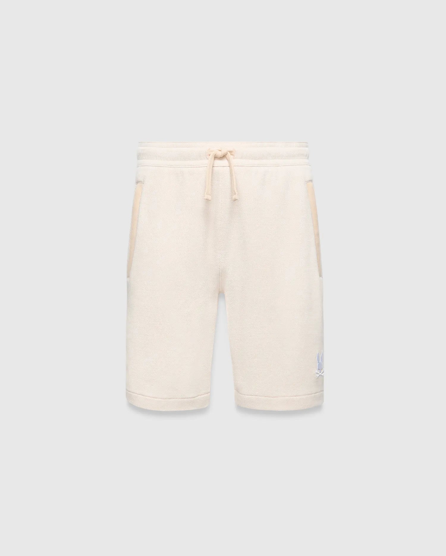 Kids Keith Short 3 1/2, a cream textured knit relaxed fit short with drawstring waist, light beige pocket trim, and a small embroidered light blue Psycho Bunny skull logo on the lower left leg.
