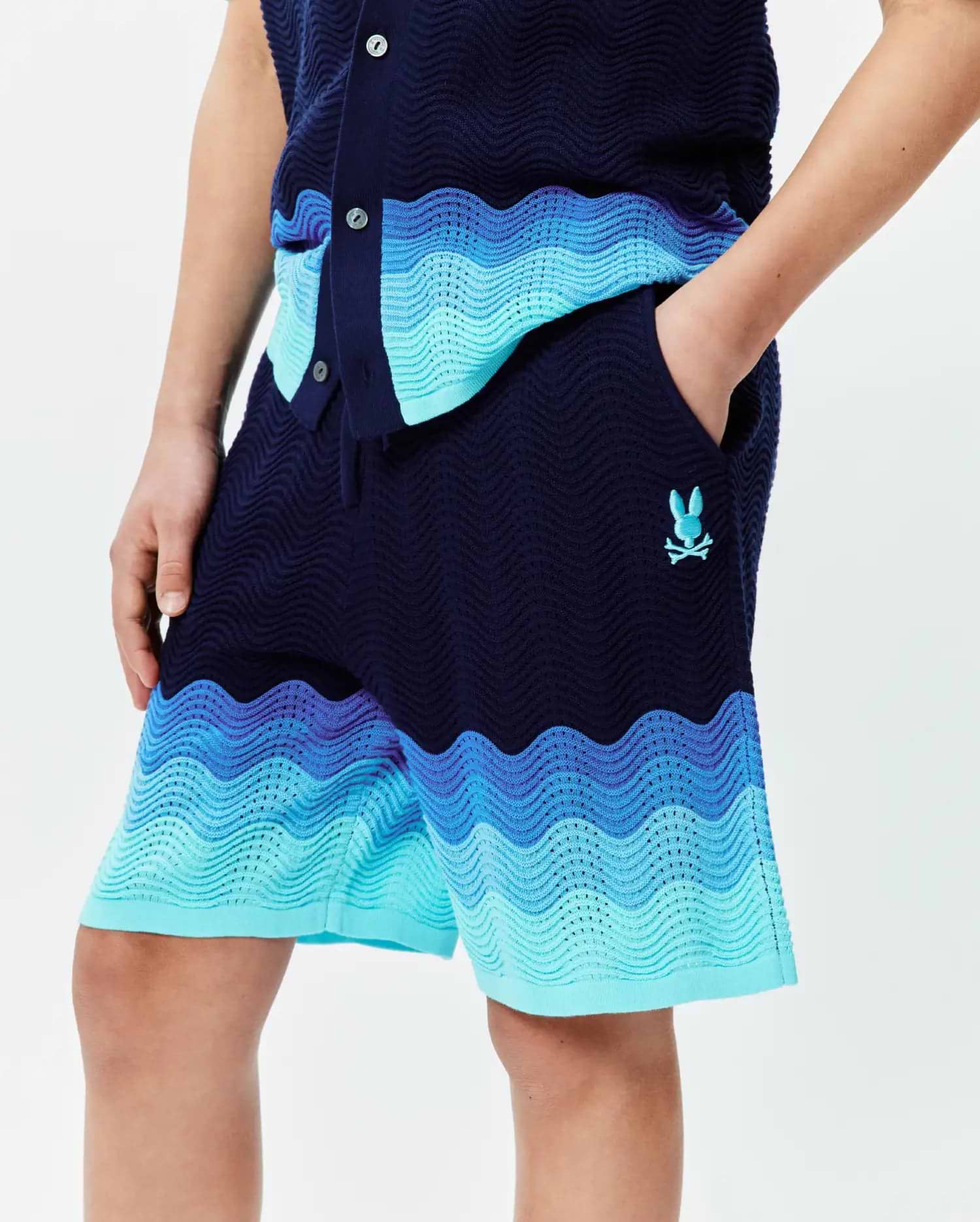 Kids Holden Knit Short in navy blue with a wavy knit texture, featuring an ombre design of royal, light, and turquoise blue bands, and a small embroidered turquoise Psycho Bunny skull logo. (2)