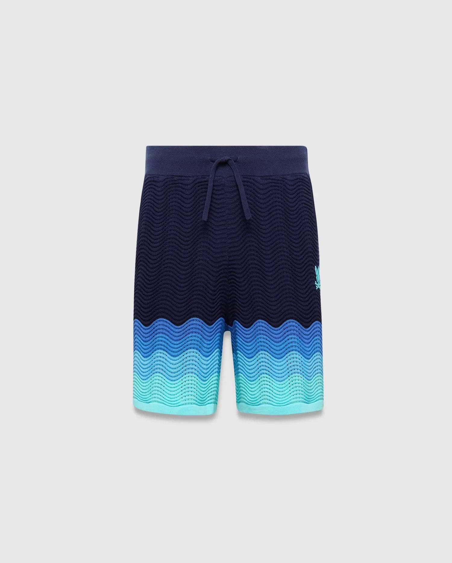 Kids Holden Knit Short in navy with a wavy knit texture, featuring a blue to teal gradient hem and a small embroidered Psycho Bunny skull logo on the right thigh. (5)