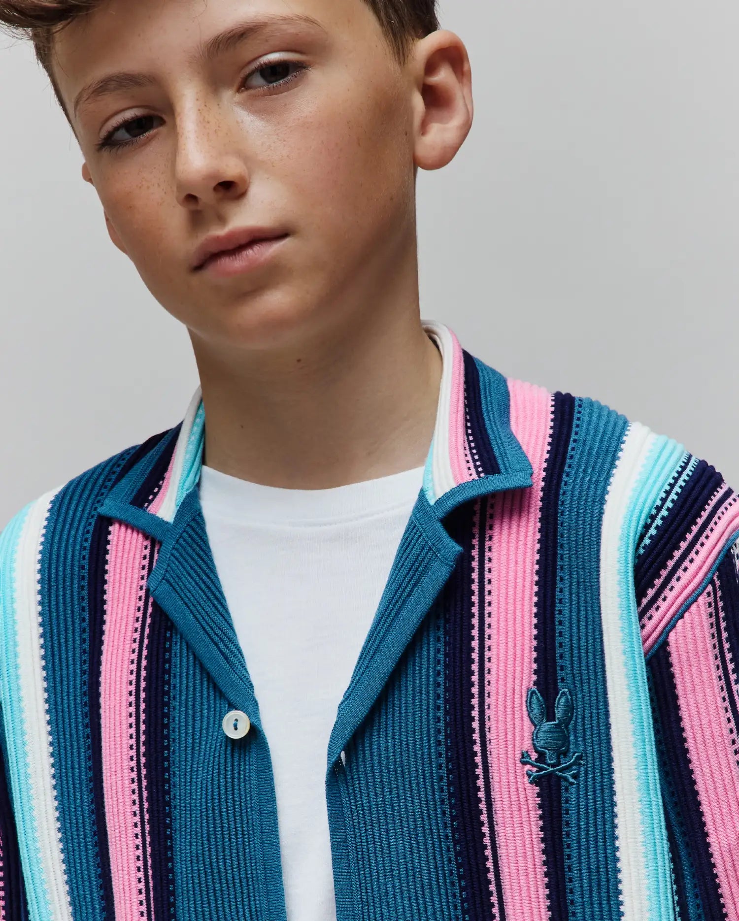 Kids Cliff Knit Shirt featuring a classic fit, vibrant vertical stripes in navy, teal, pink, and white ribbed knit, with a small embroidered Psycho Bunny logo on the left chest.