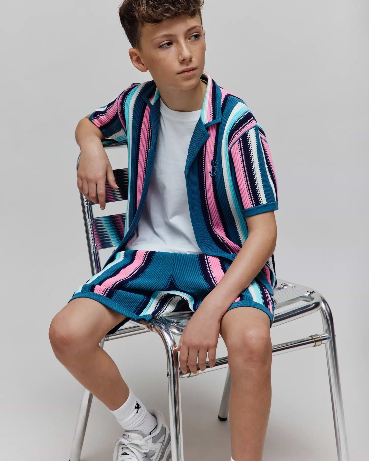 Kids Cliff Knit Shirt and matching shorts featuring vibrant teal, pink, white, and black striped ribbed knit fabric, with a small embroidered Psycho Bunny skull logo on the left chest.