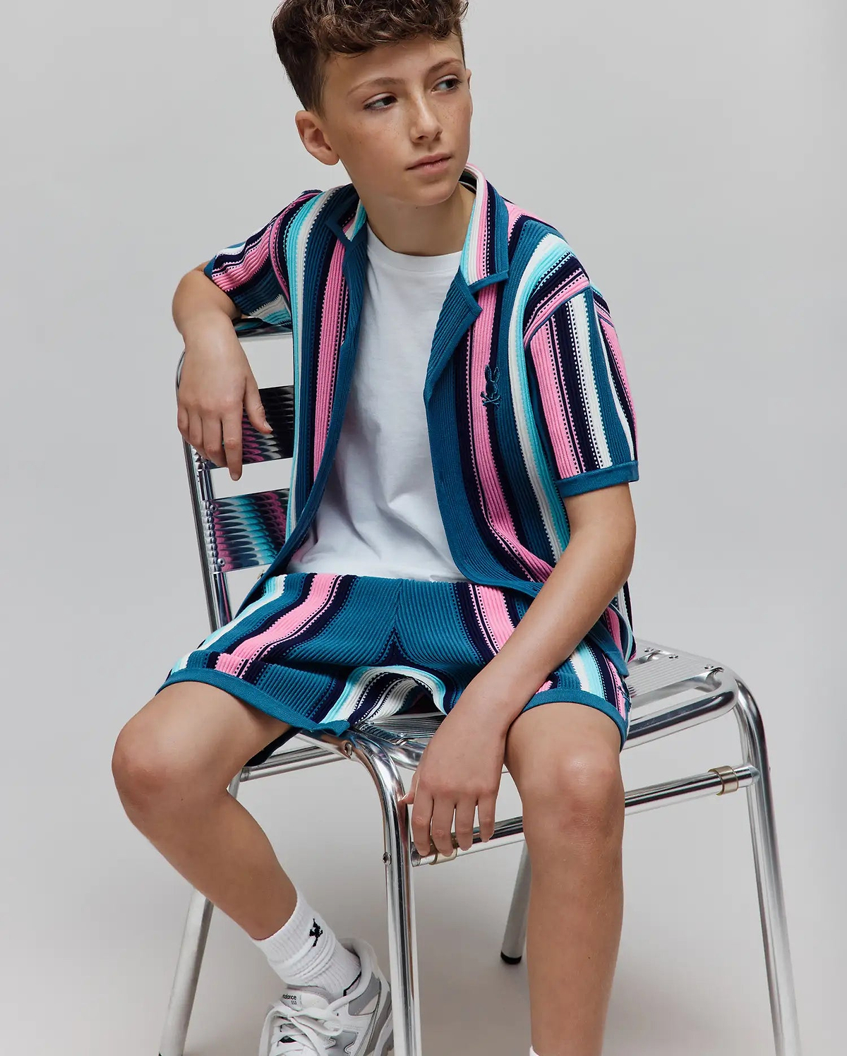 Kids Cliff Knit Shirt and matching shorts featuring vibrant teal, pink, white, and black striped ribbed knit fabric, with a small embroidered Psycho Bunny skull logo on the left chest.