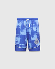 Kids Micah Soccer Short in blue with a distressed light blue checkered pattern, white drawstring, and white piping. Features a circular Psycho Bunny Football Club logo with a bunny skull and stars on the right leg.