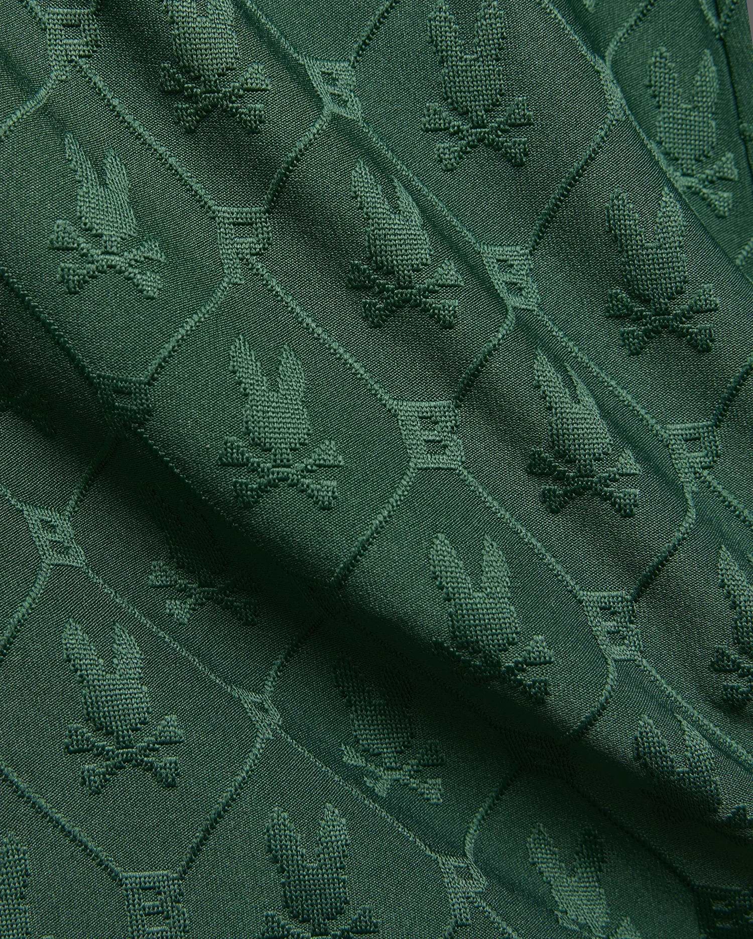 Kids Garry Jacquard Sweatshort in deep forest green, featuring an all-over textured jacquard knit pattern of the iconic Psycho Bunny skull logo within diamond shapes.
