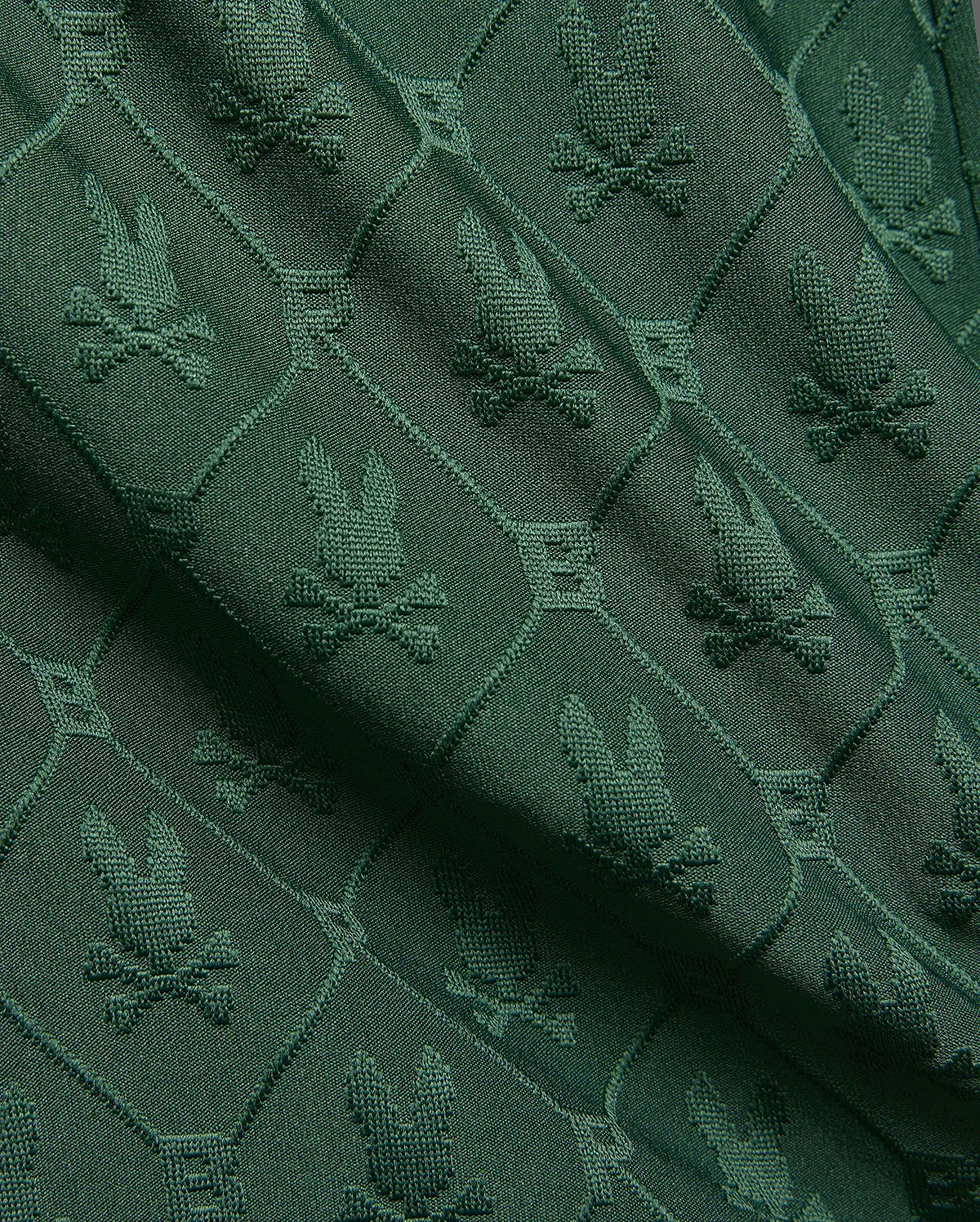Kids Garry Jacquard Sweatshort in deep forest green, featuring an all-over textured jacquard knit pattern of the iconic Psycho Bunny skull logo within diamond shapes.
