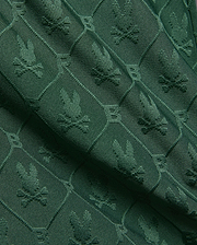 Kids Garry Jacquard Sweatshort in deep forest green, featuring an all-over textured jacquard knit pattern of the iconic Psycho Bunny skull logo within diamond shapes.