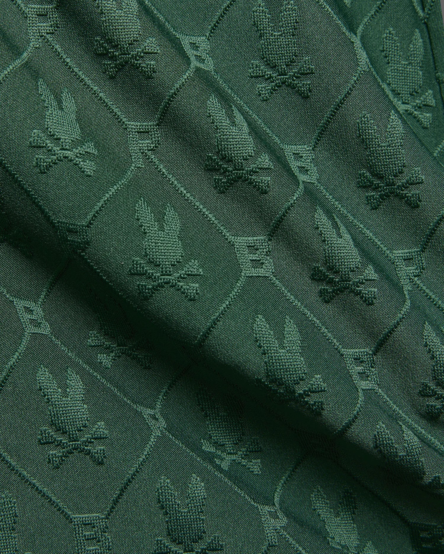 Kids Garry Jacquard Sweatshort in deep forest green, featuring an all-over textured jacquard knit pattern of the iconic Psycho Bunny skull logo within diamond shapes.