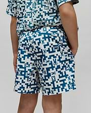 Kids Josh Swim Trunk in white with a teal pixelated geometric pattern featuring small Psycho Bunny skull logos throughout, a classic fit, and smooth quick-dry fabric. (3)