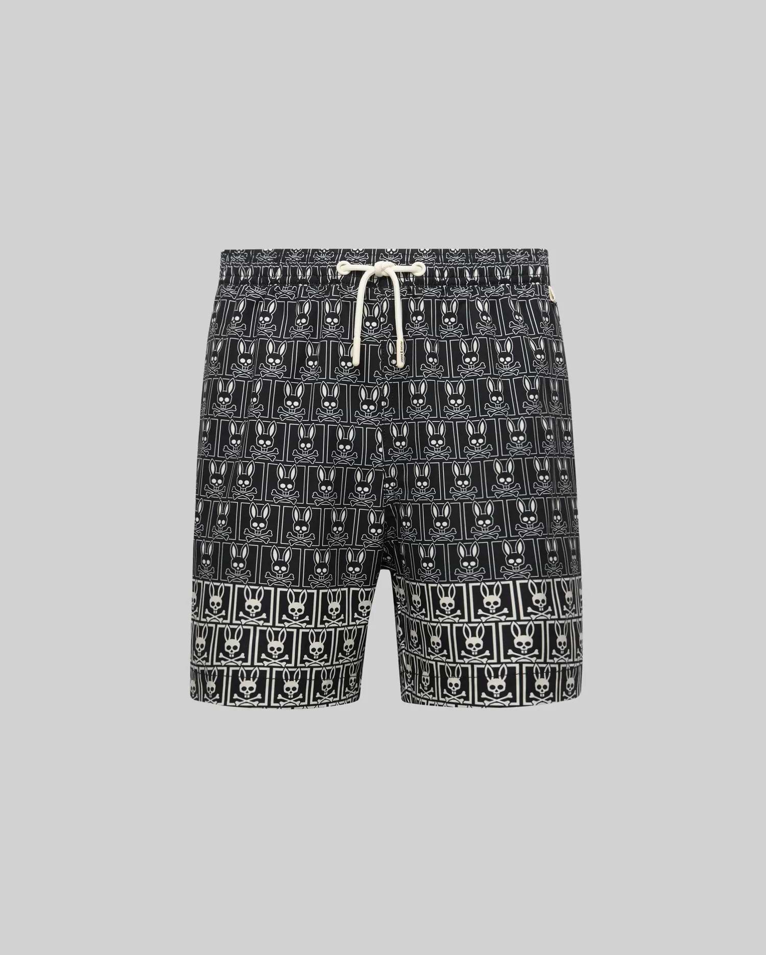Kids Keon Swim Trunk in black, featuring a bold all-over white Psycho Bunny skull logo grid pattern and a contrasting white drawstring. This relaxed-fit swim trunk is designed for comfort. (5)