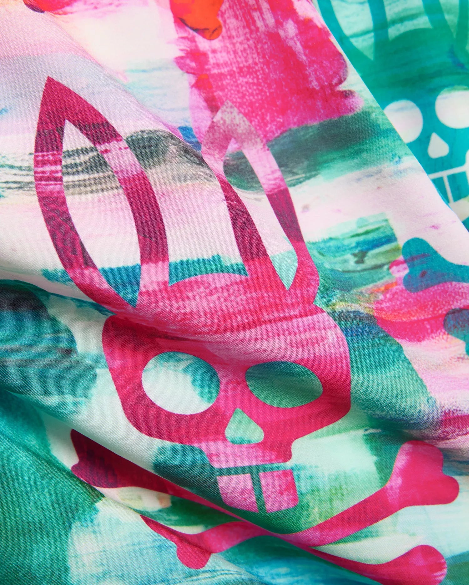 Kids Nate All Over Print Swim Trunk with a vibrant abstract watercolor pattern in hot pink, teal, and green, featuring large repeating Psycho Bunny skull and crossbones logos on smooth fabric.